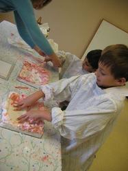kids marbelizing paper with shaving cream and a small quantity of paint