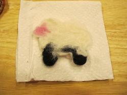 a cookie cutter sheep made with wool roving